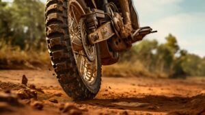 Wallpaper showcasing the gritty and adventurous spirit with a close up of a dirt bikes rugged tire kicking up dirt on a dirt trail