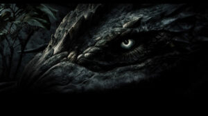 Closup of a dinosaur's eye in a dark setting makes an intimidating wallpaper