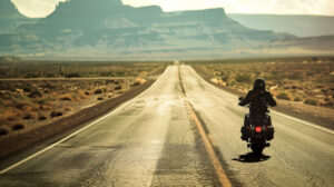 A lone rider cruising along a deserted desert highway, with the vast expanse of the open road stretching out before them