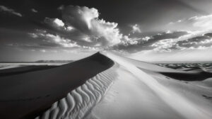 A peaceful black and white wallpaper featuring a desert scene with sand dunes extending towards the horizon under a vast sky