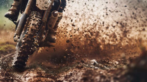 A close up of a dirt bike speeding through a muddy trail, with dirt flying up and the rider leaning into a sharp turn, showcasing the thrill of off road racing