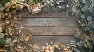 An artfully scattered serene arrangement of dried flowers in muted shades on a rustic wooden surface makes for a soothing wallpaper backdrop