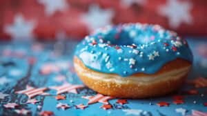 A patriotic themed wallpaper featuring a donut with blue icing and star shaped sprinkles set against the background