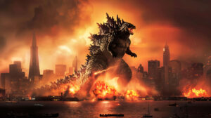 A wallpaper showing Godzilla roaring amidst a city skyline with skyscrapers collapsing around it flames illuminating the night