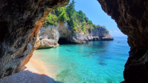 Discover a secluded beach embraced by a natural rock arch presenting an idyllic ocean view. Capture this scene in wallpaper perfect view.jpg